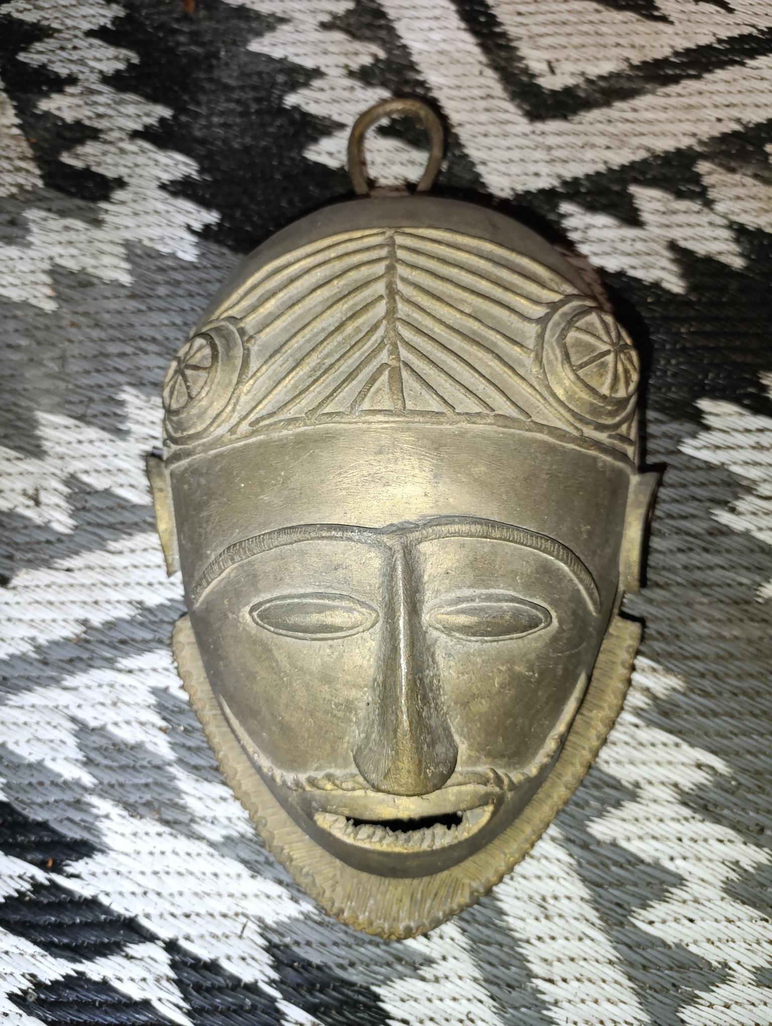 Masque africain décoratif en métal patiné